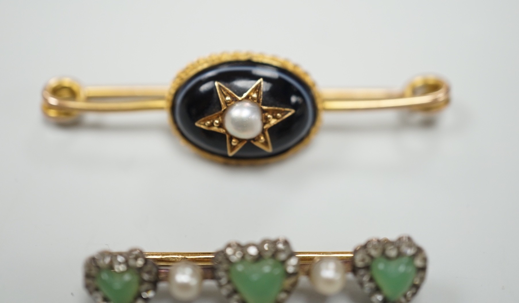 An early 20th century Austro-Hungarian? yellow metal, chrysoprase, rose cut diamond and seed pearl, set triple heart motif bar brooch, 32mm and a Victorian banded agate and split pearl set bar brooch